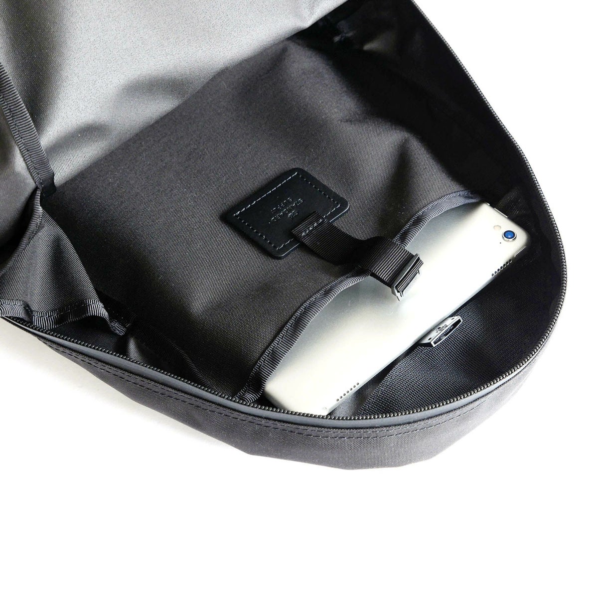 背面側には、プラスチックパーツで留められる</br>スリットポケットがありA4サイズも入ります。